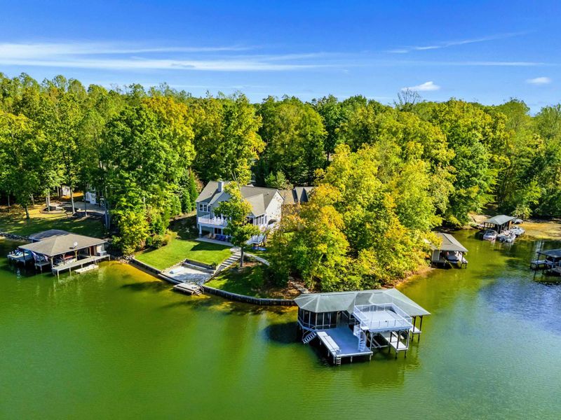Aerial View - Wider perspective captures the property's generous waterfront lot and private cove setting.