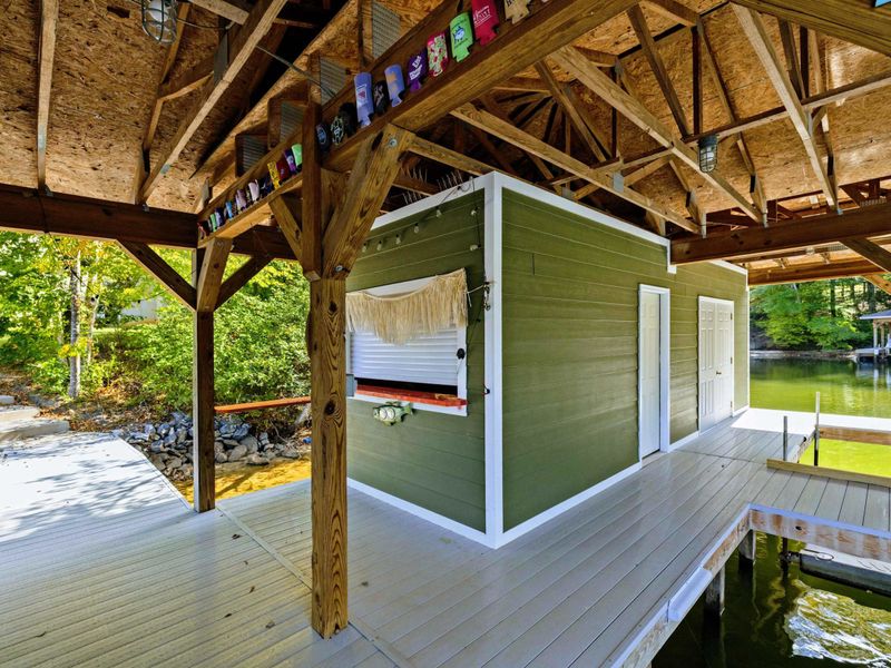Boathouse - Open-air lower level with bar and seating tucked beneath the timber frame structure.