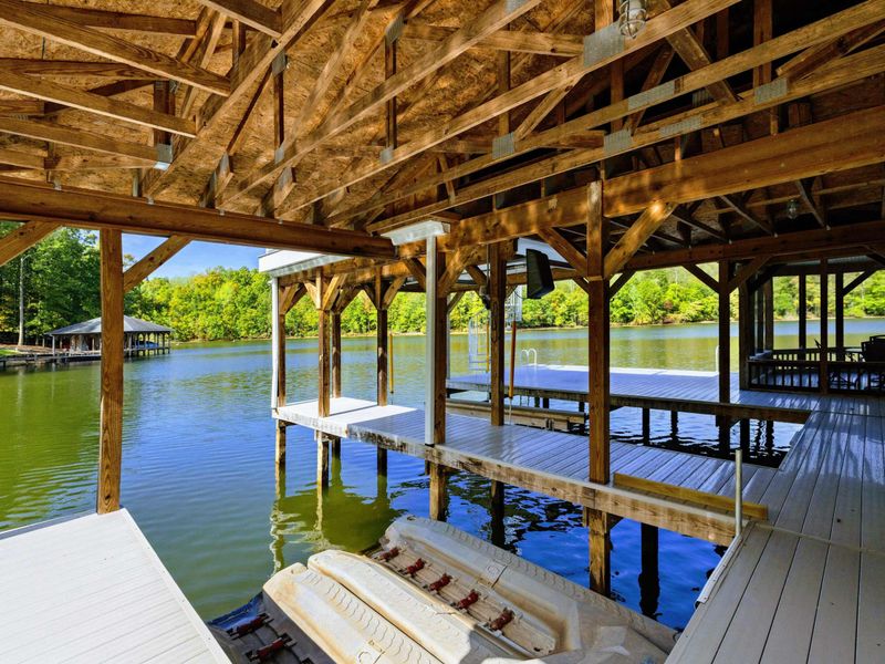 Boathouse - Timber frame interior with bench seating along the covered dock and open water views.