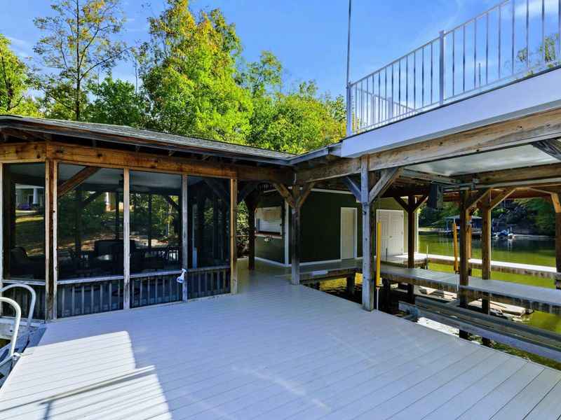 Boathouse - Full exterior showing the screened porch, sun deck, and dock platform at water level.