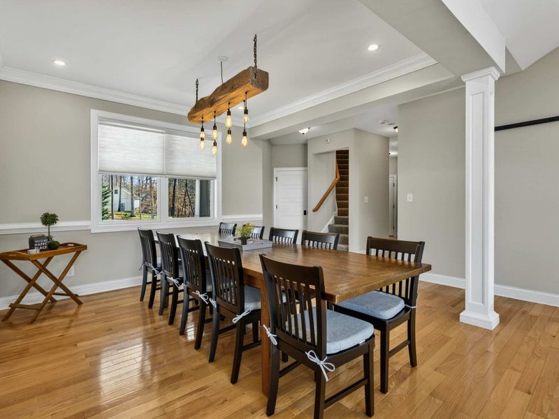 Dining Area - The beam chandelier and large windows bring warmth and natural light to the dining space.