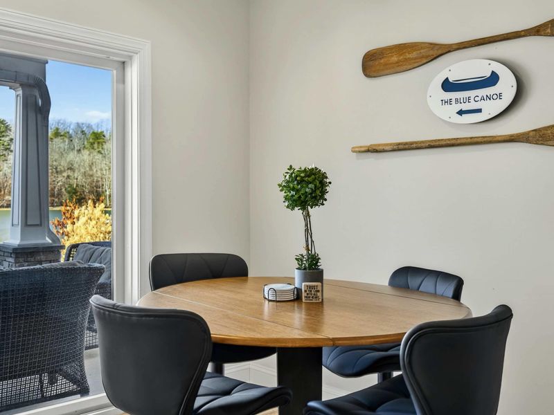 Dining Nook - Cozy four-top table with lake views through the sliding door to the patio.