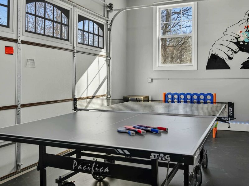 Game Room - Ping pong table with paddles ready to play, bold wall art adding energy to the space.