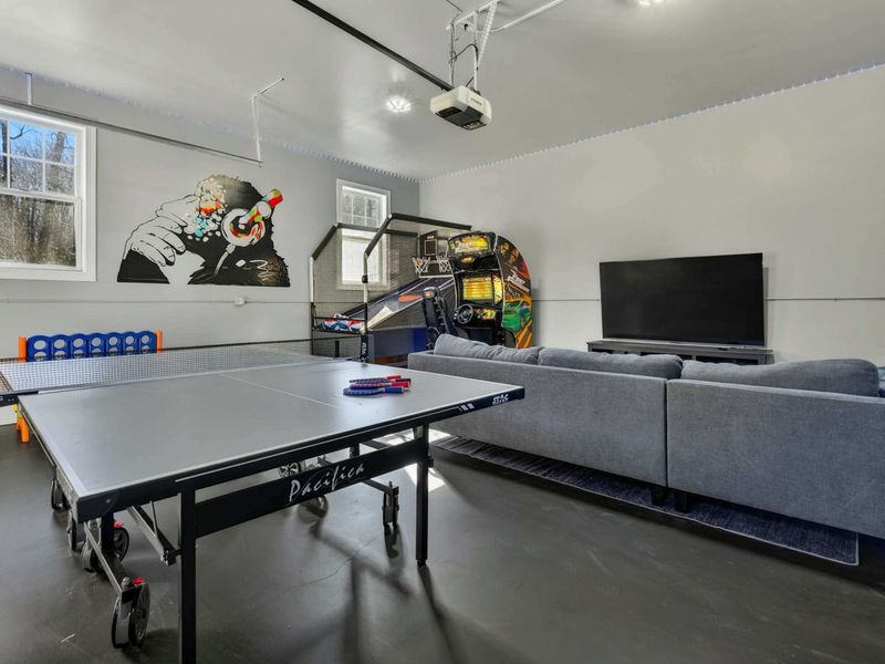 Game Room - Ping pong table, arcade basketball, racing simulator, and big-screen TV fill this converted garage space.