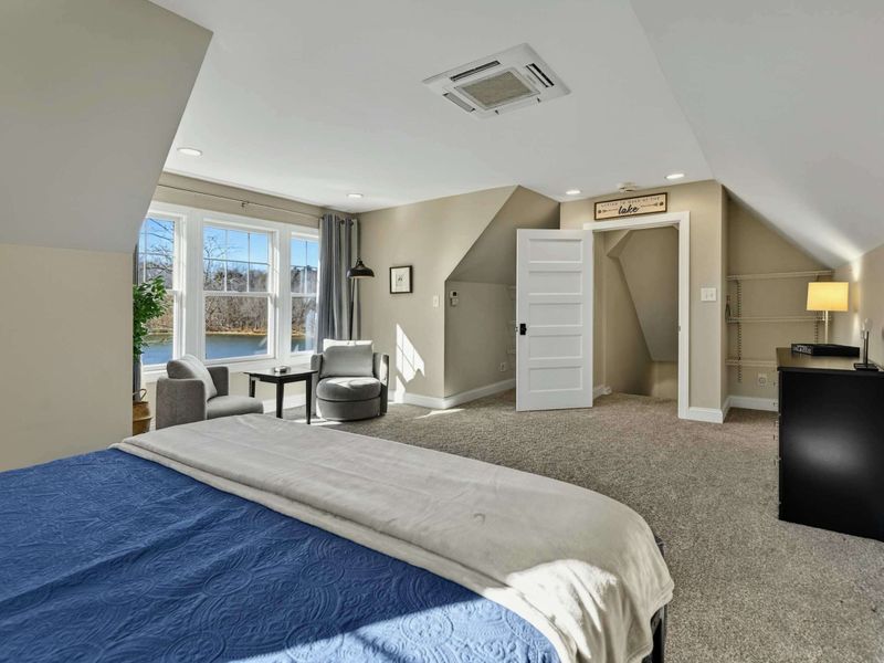 Bedroom 2 - Sitting nook with accent chairs, walk-in closet, and windows with lake and tree views.