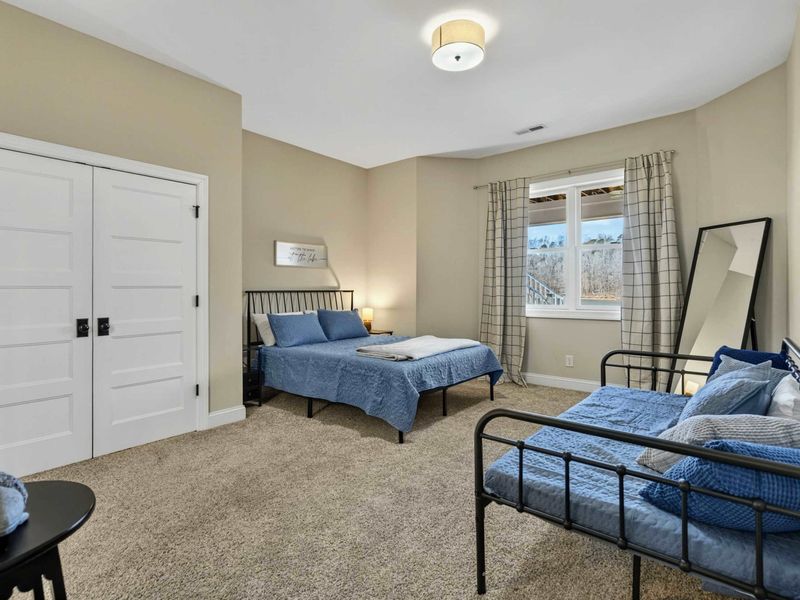 Bedroom 3 - Queen bed and twin daybed with coordinating blue bedding, plaid curtains, and compass wall art.