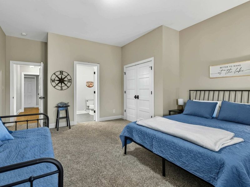 Bedroom 3 - Full room view with bathroom entry, closet, and lake-themed wall decor.