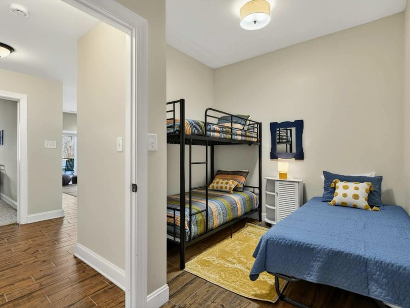 Lower Bunk Room - Twin bunk bed and single bed on the lower level with cheerful yellow and blue decor.