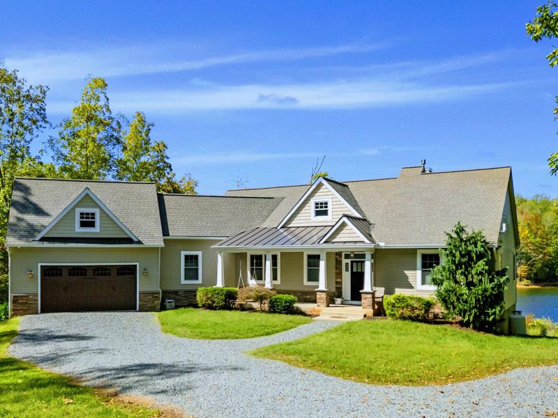 Exterior - Craftsman facade with stone accents, metal roof detail, two-car garage, and covered front porch.