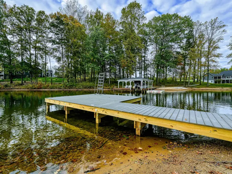 Waterfront - View from the water showing the dock platform and walkway leading up to the home through the tree-lined property.