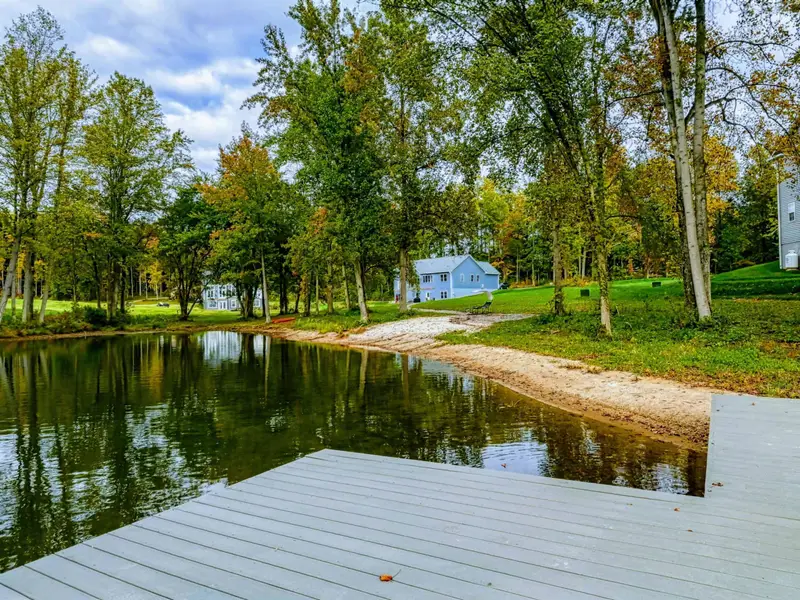 Waterfront - Sandy shoreline and winding pathway through the wooded property connect the dock to the home.