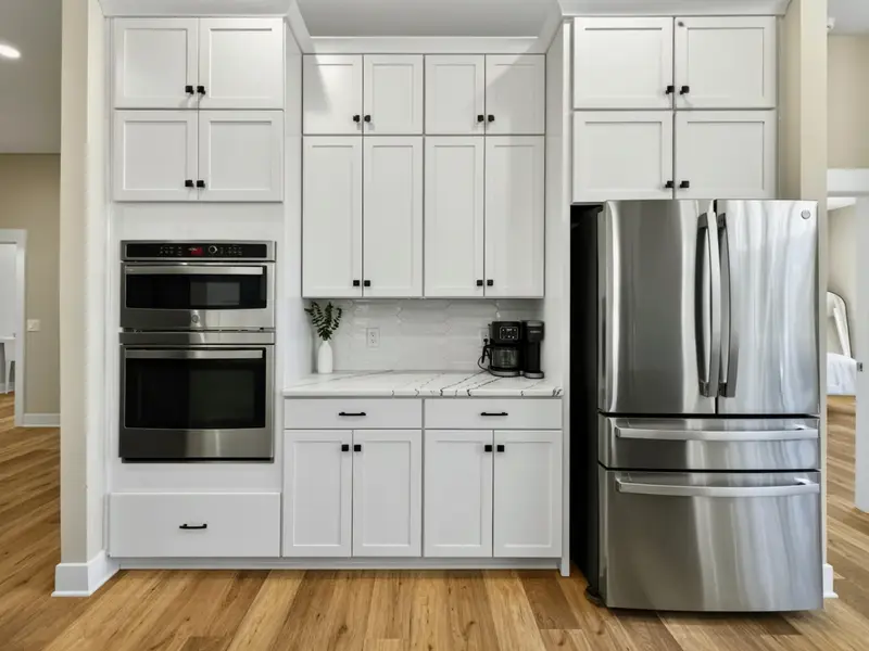 Appliance Wall - A built-in oven, microwave, and French-door refrigerator anchored by white cabinetry.