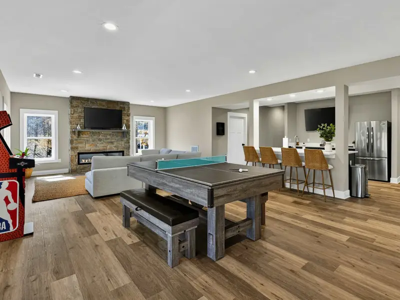 Game Room Panorama - The full spread of the lower level in one shot: pool table, sectional, fireplace, bar stools, and arcade.