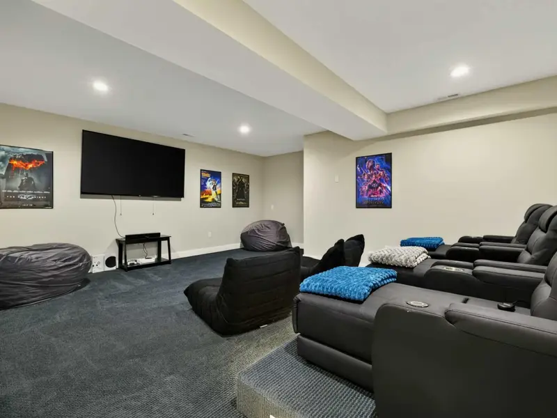 Home Theater - Plush recliners, a big-screen TV, and movie posters set the stage for the ultimate movie night.