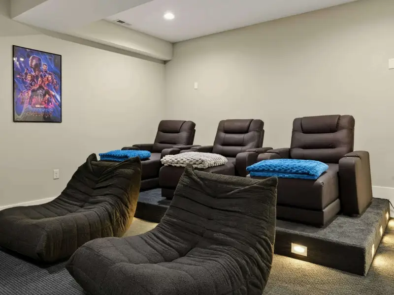 Movie Night Setup - Plush recliners with chunky knit blankets and mood lighting for the ultimate home theater experience.