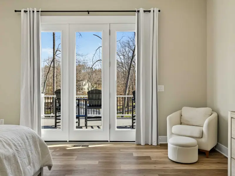 Deck Access - French doors open from the primary suite to the deck, letting in natural light and lake views.