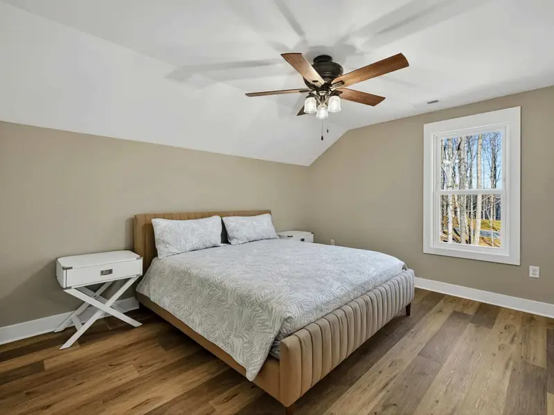 Upper Bedroom - A king bed, ceiling fan, and patterned comforter make this upper room a comfortable retreat.