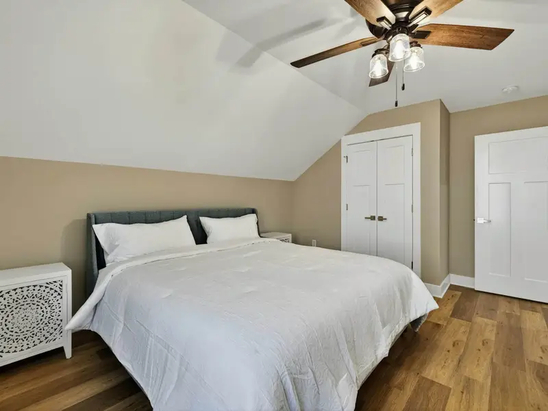 Upper Bedroom - A king bed, decorative nightstand, and vaulted ceiling give this room its own character.
