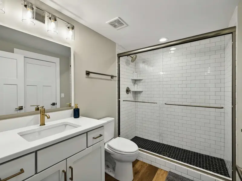 Lower Level Bath - A full shared bath with subway-tile shower, vanity, and clean finishes on the lower level.