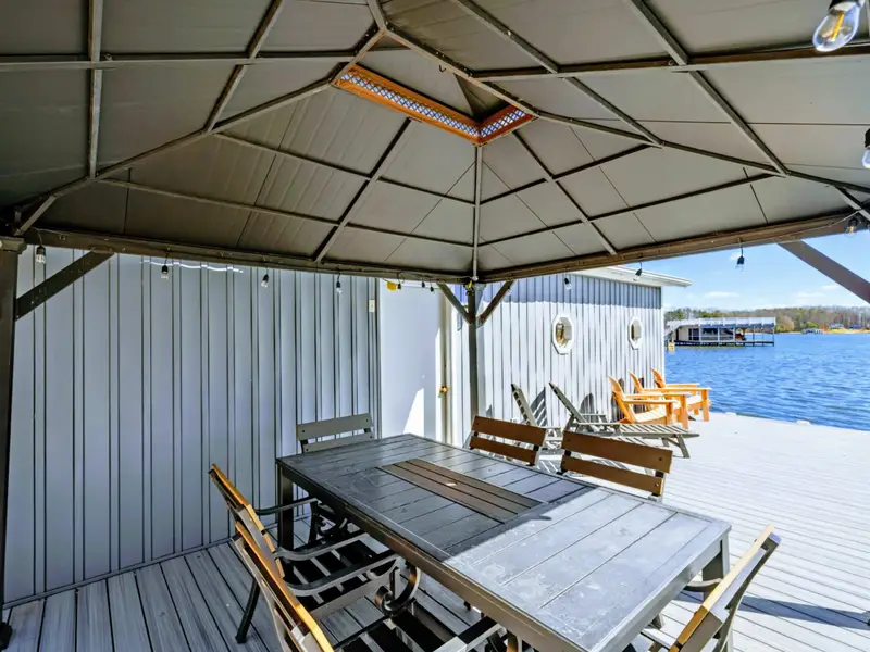 Gazebo Detail - An overhead heater and string lights extend the season for waterside dining, with the dock and lake just beyond.