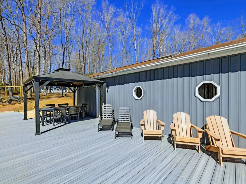 Boathouse Deck - The converted boathouse deck features a covered gazebo for dining, Adirondack chairs, and porthole windows for a charming lakeside hangout.