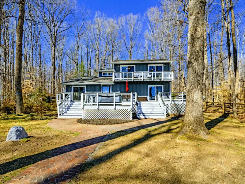 Front Exterior - Another angle of the home shows the full facade, brick path, and wooded setting that gives Ataraxia Cove its peaceful character.