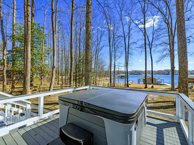 Hot Tub - The 7-person hot tub sits on its own deck platform, surrounded by tall trees and lake views in every direction.