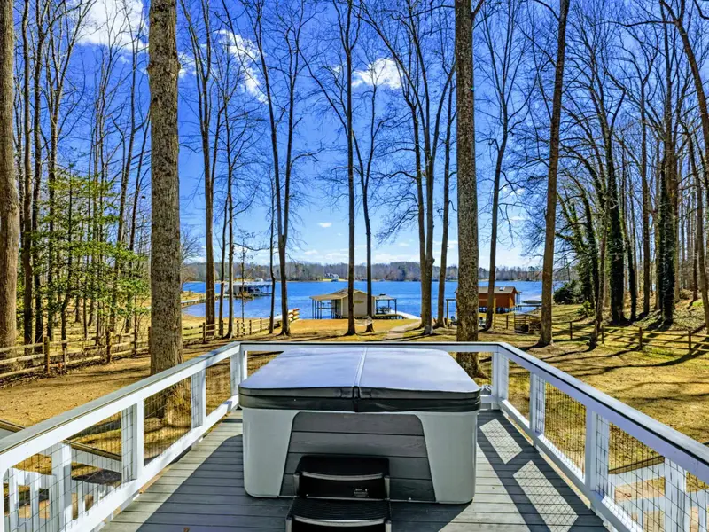 Hot Tub and Lake - Straight ahead from the hot tub, the dock and boathouse frame the lake view through the trees.