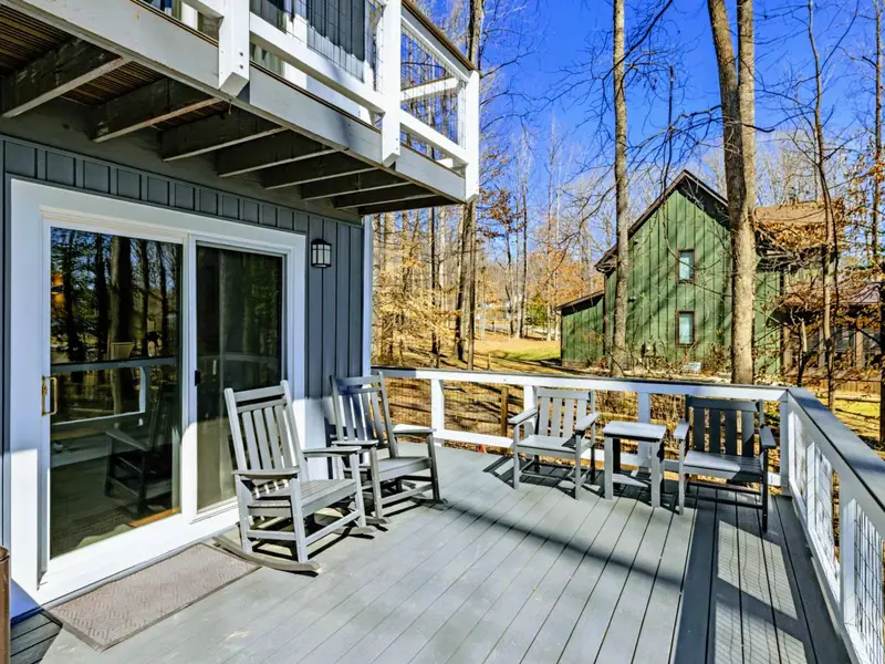 Lower Deck - Rocking chairs and a bench on the lower deck offer a quiet spot to relax, with sliding glass doors into the main-level bedroom.