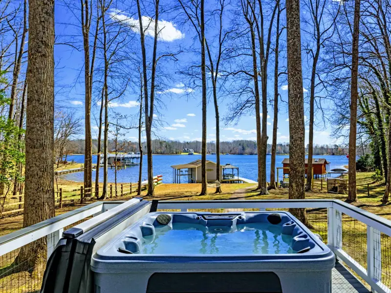 Hot Tub - Soak in the 7-person hot tub with lake views through the trees, just steps from the dock and sandy beach below.