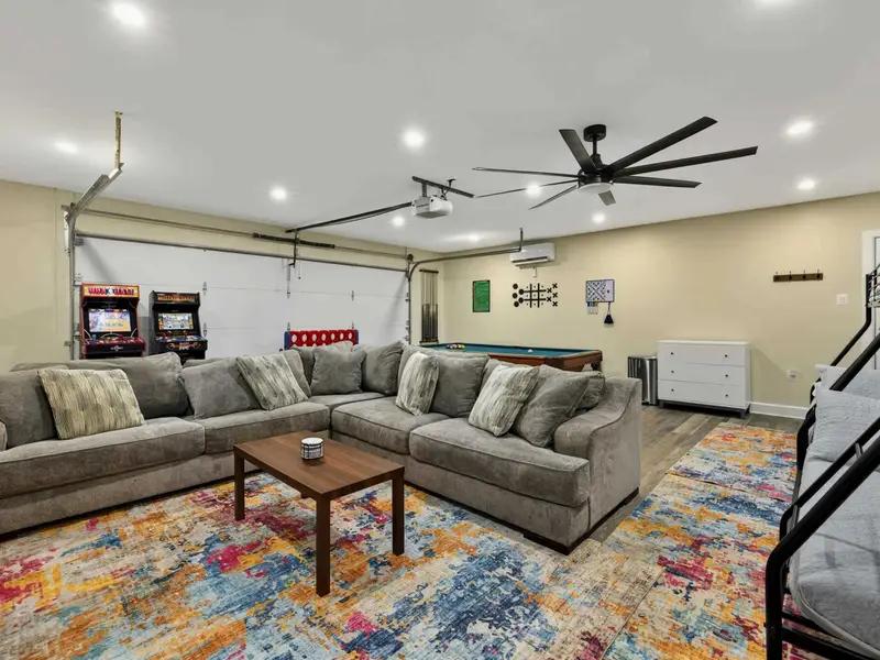 Game Room - The converted garage is packed with fun: a pool table, two arcade cabinets, Connect 4, wall-mounted games, a sectional, bunk beds, and a colorful rug tying it all together.