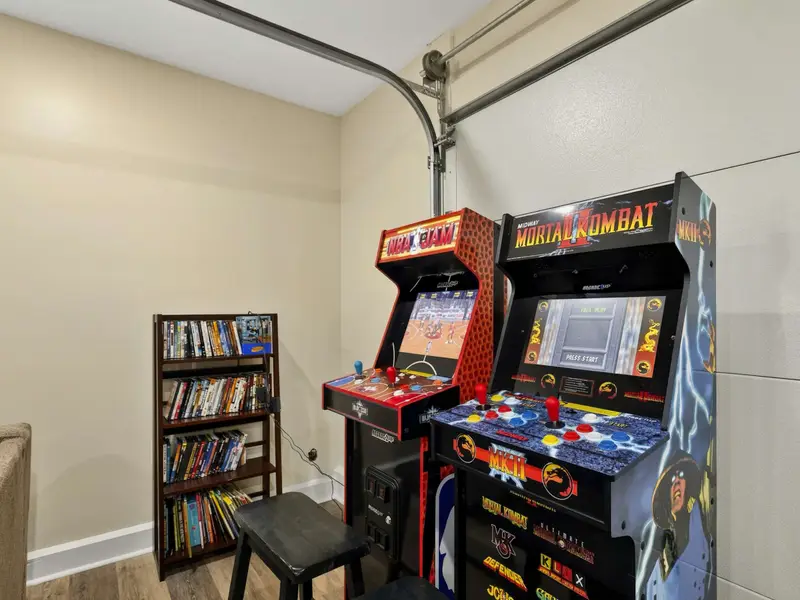Arcade Corner - NBA Jam and Mortal Kombat stand-up arcade cabinets bring classic gaming to the game room, with a shelf of DVDs for movie night options.