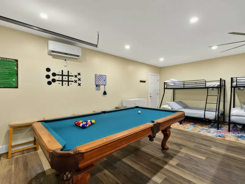 Pool Table - A full-size pool table with wall-mounted tic-tac-toe and Scrabble boards sits alongside the bunk beds in the game room.