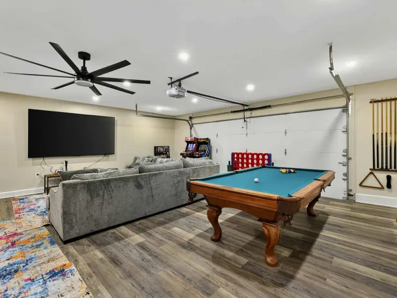 Game Room - The full converted garage brings together a pool table, 100-inch TV, sectional, arcade cabinets, Connect 4, and a cue rack for nonstop entertainment.