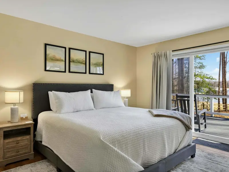 Primary Suite - The sliding glass door fills the room with natural light and puts the deck, trees, and lake just one step away.
