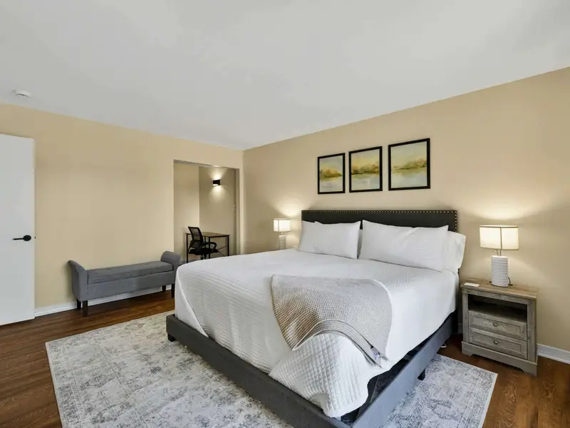 Primary Suite - The spacious layout includes a king bed, upholstered bench, closet, and a private desk nook for anyone who needs to catch up on work.