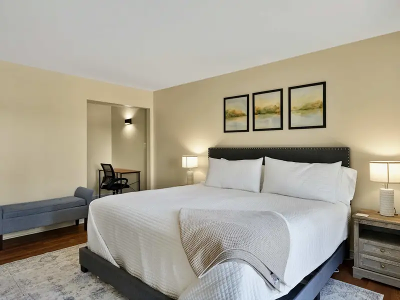 Primary Suite - A comfortable bench at the foot of the bed and a desk alcove just around the corner add thoughtful touches to the main-level bedroom.