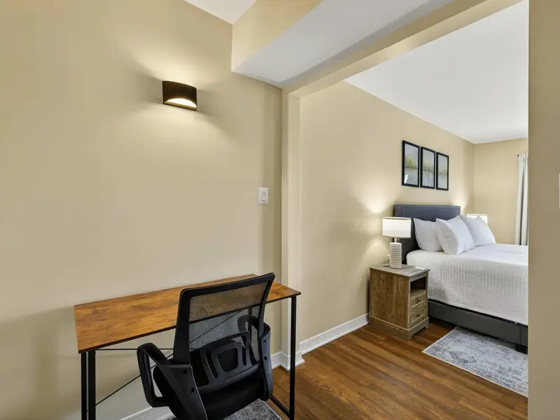 Desk Nook - A compact work desk with an ergonomic chair and wall sconce sits in a quiet alcove off the primary bedroom, ideal for remote work.