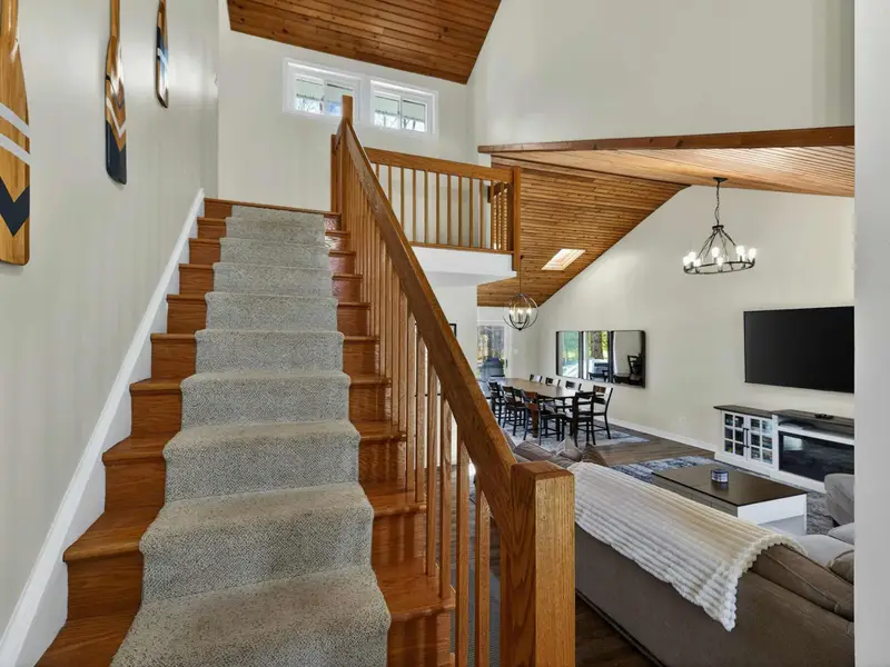 Staircase Detail - An oar mounted on the vaulted wood ceiling adds a lakehouse touch as you head upstairs to the bedrooms.