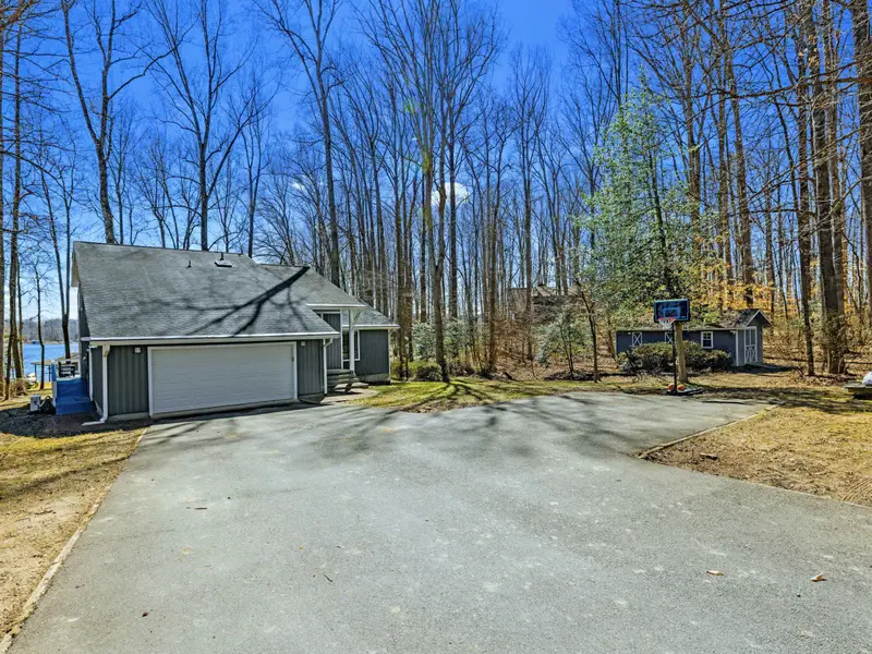 Welcome Home - The front approach to Ataraxia Cove, with a two-car garage and tree-lined driveway.