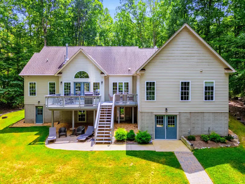 The rear of the home tucked into the trees. Private, wooded, and steps from the water.