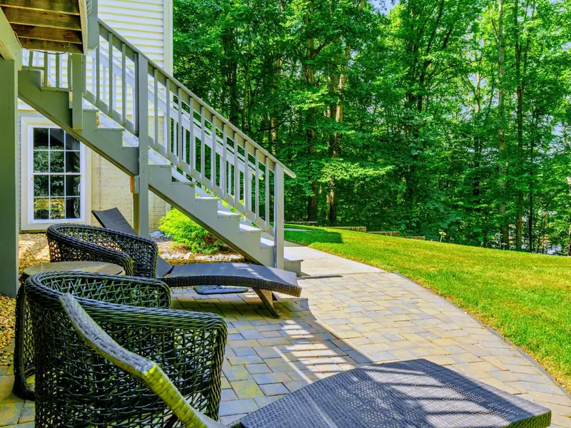 Paver patio with lounge chairs and easy access to the upper deck and yard.