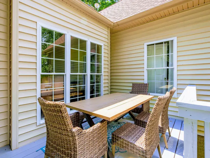 Covered porch with outdoor dining. Protected from sun and rain, open to the breeze.