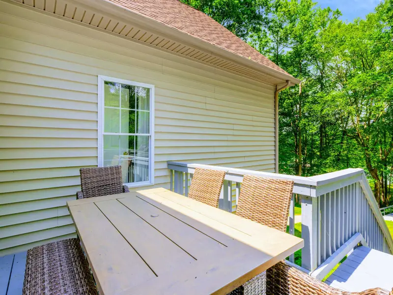 The screened porch: bug-free evenings, wrought iron dining, and a view of the trees. A favorite spot after dark.