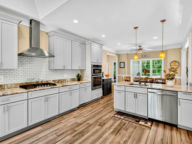 Everything a serious cook needs: white cabinetry, center island, pendant lighting, and an open layout so no one misses the conversation.
