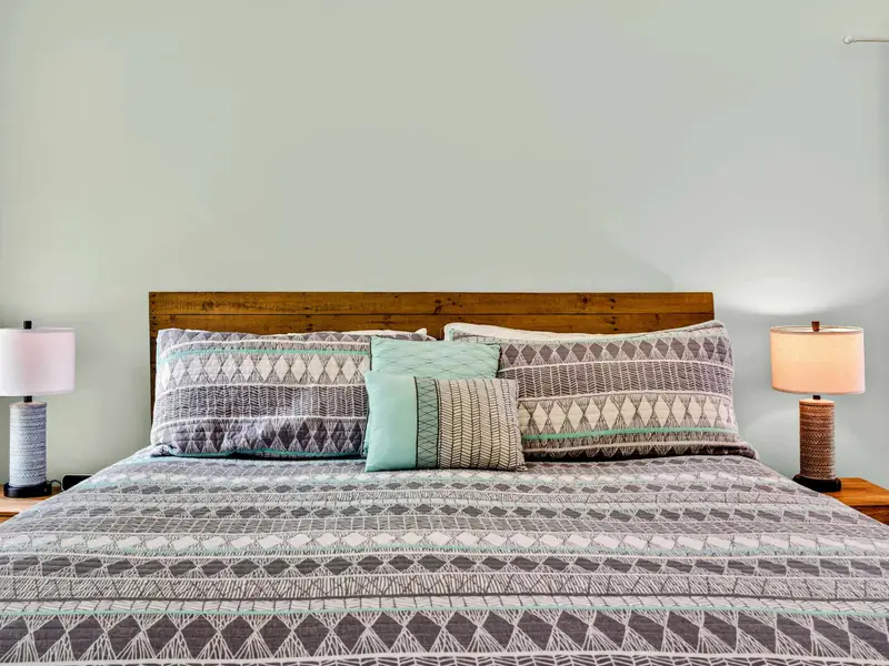 King bed with a patterned quilt and matching nightstands. Comfortable, clean, and ready for a long night's rest.