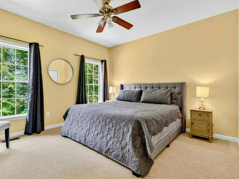 Bedroom 2: king bed on the main level with a ceiling fan and blackout-ready curtains. Quiet and private.