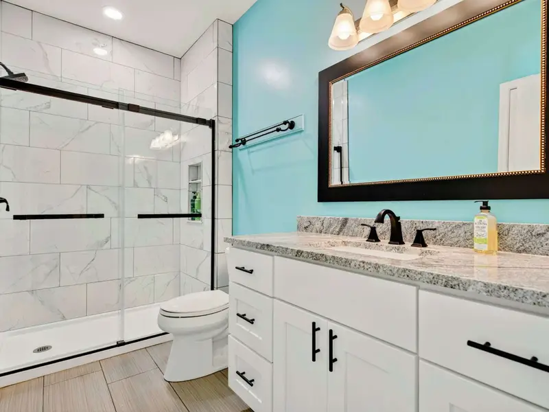 A modern hall bath with turquoise accents and glass shower. Bright, clean, and designed with care.