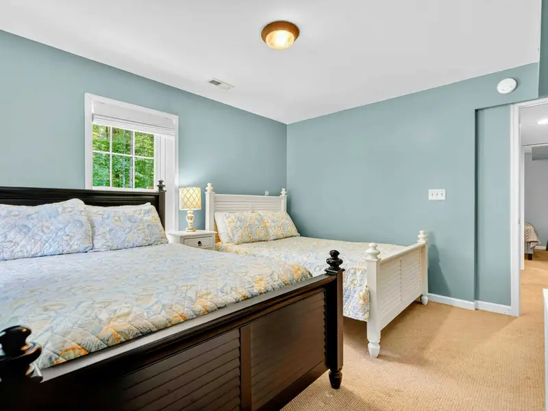 Vaulted ceiling and soft natural light make this lower level guest room feel open and restful.