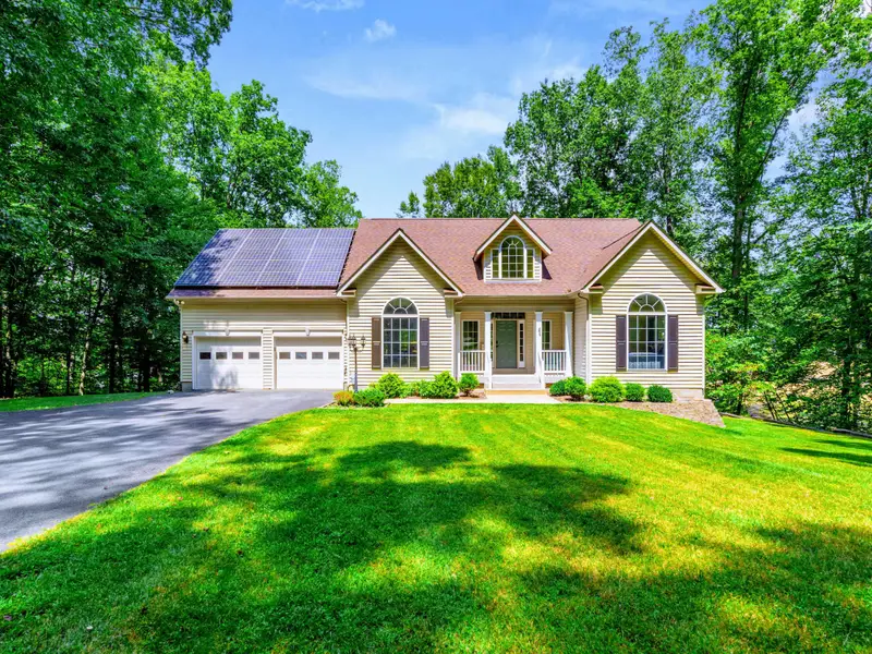 The home sits back from the road on a quiet, tree-lined lot with a paved driveway and room for 10 vehicles.
